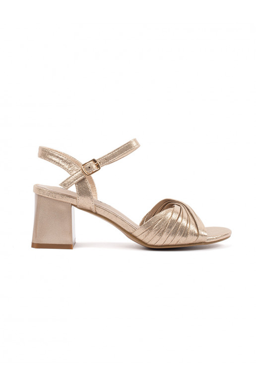 gold color elegant sandals on a low post